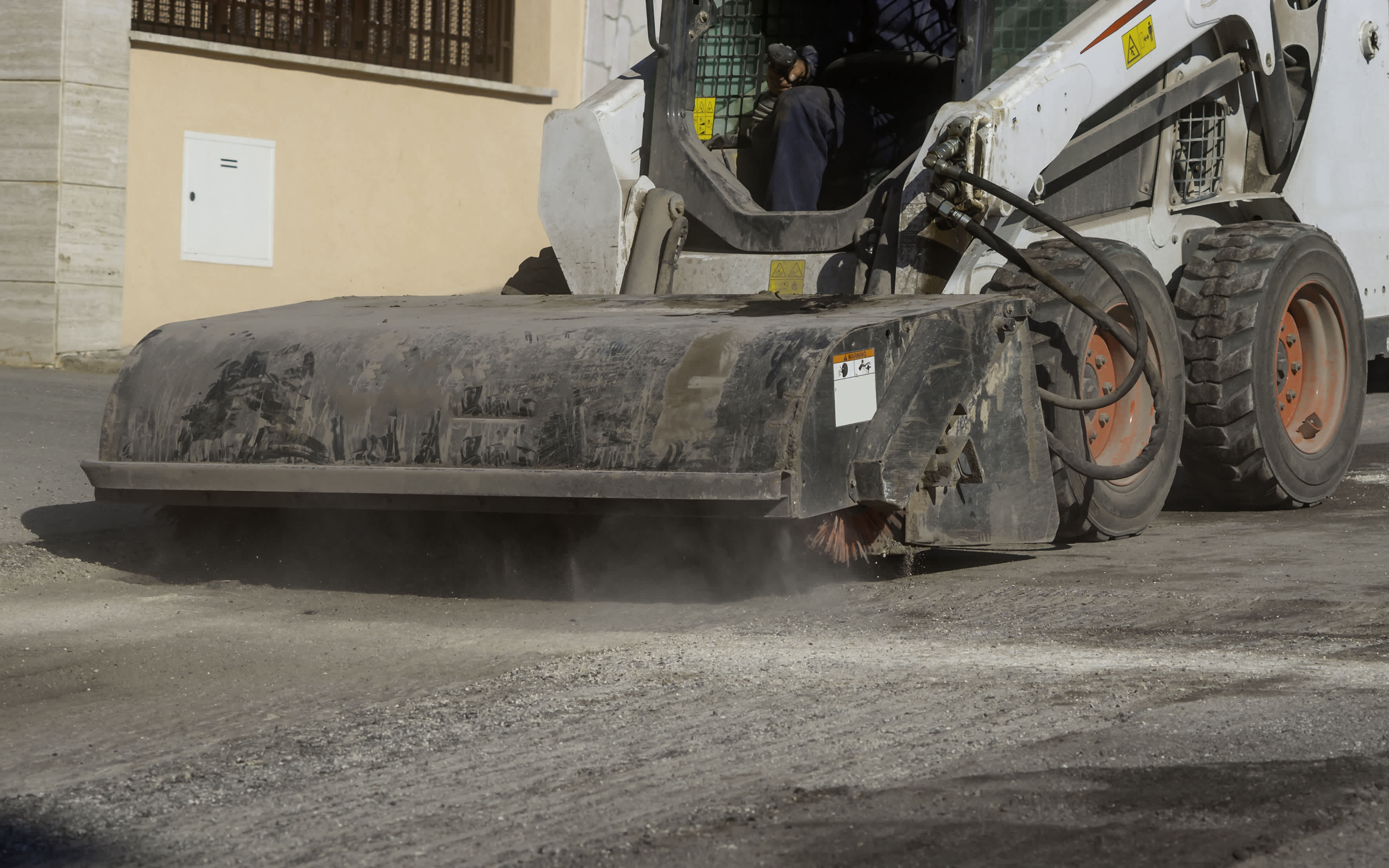 Skid steer with sweeper attachment